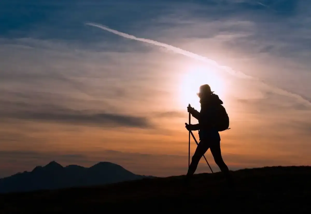 Peregrino caminando a la luz del amanecer