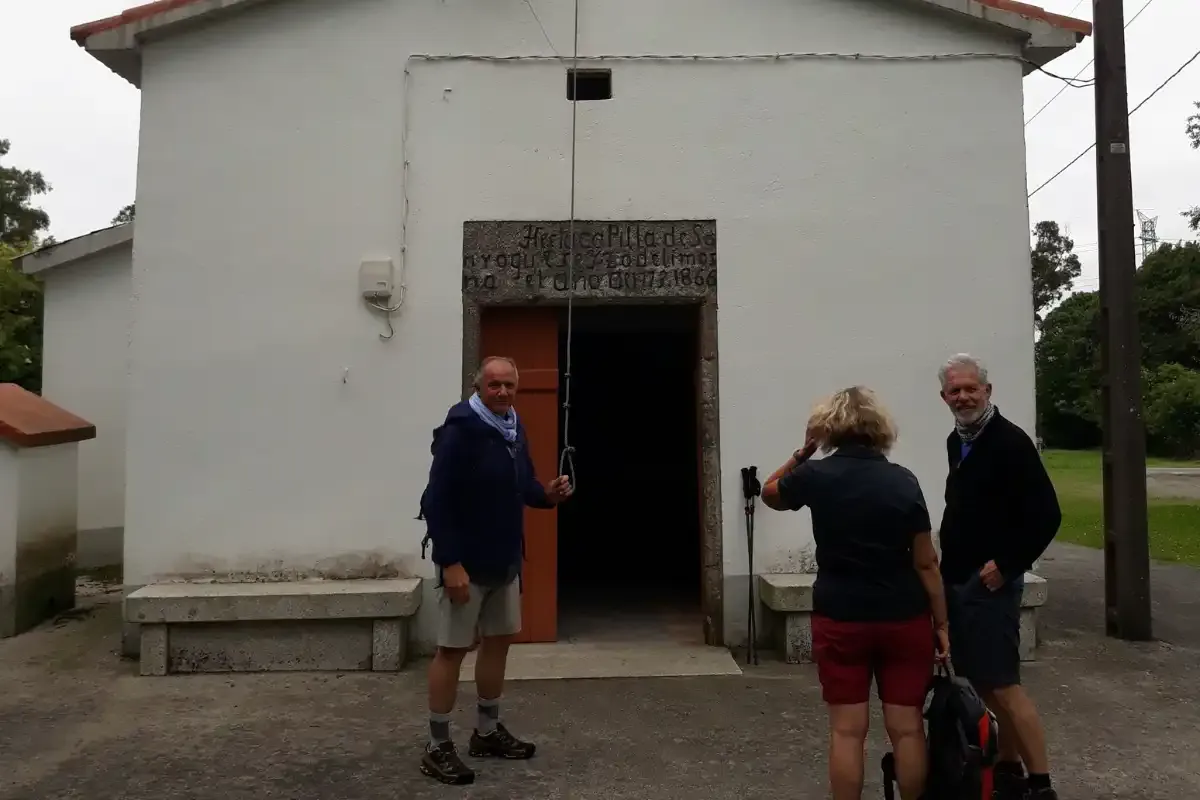 Peregrinos tocando la campana en la Ermita de San Roque