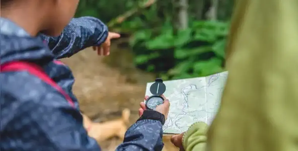 Un bambino con una mappa e una bussola sul Cammino di Santiago