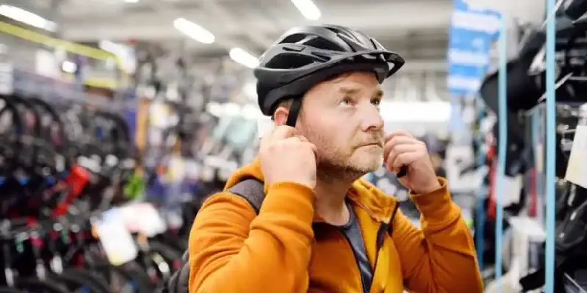 Peregrino probando un casco de bicicleta