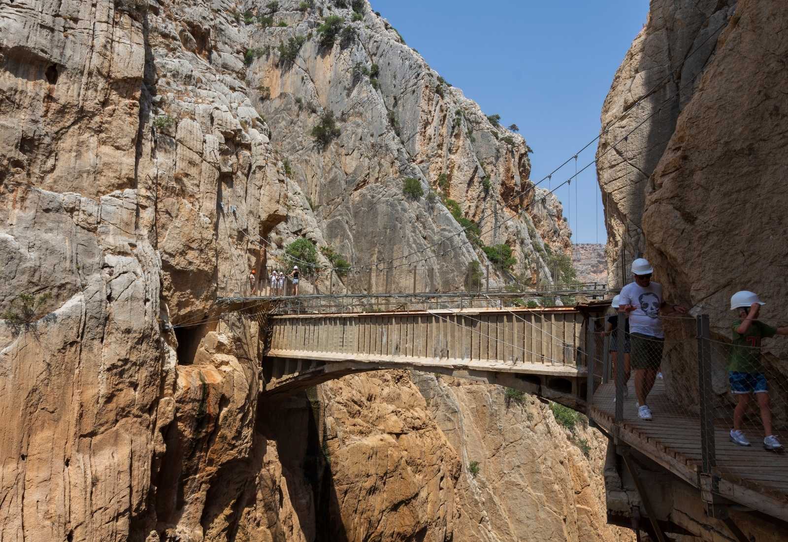 Personnes portant des casques traversant le pont Caminito del Rey