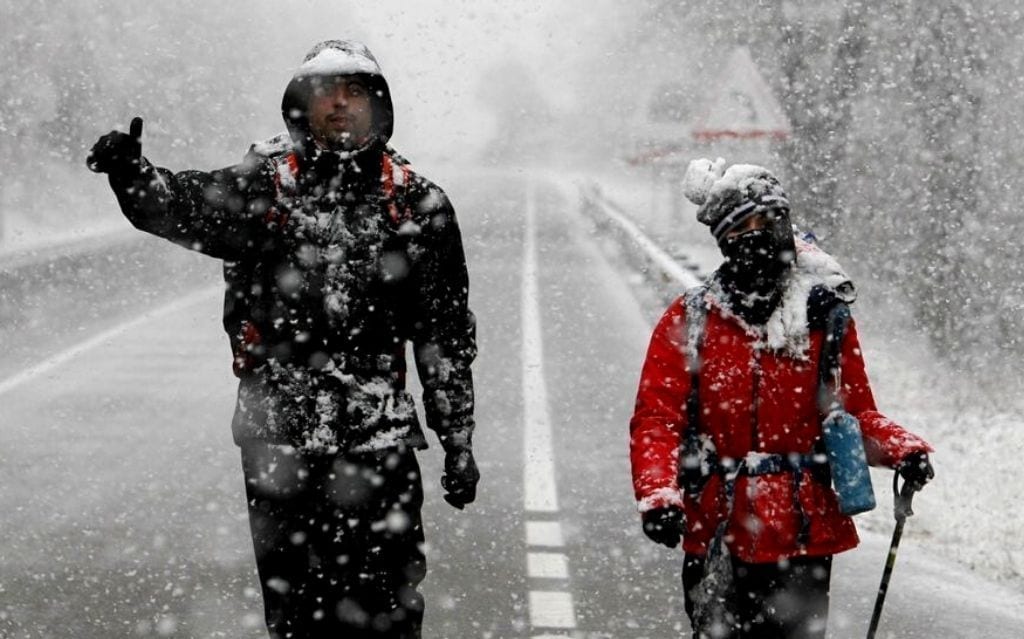 Dos personas caminando bajo la nieve