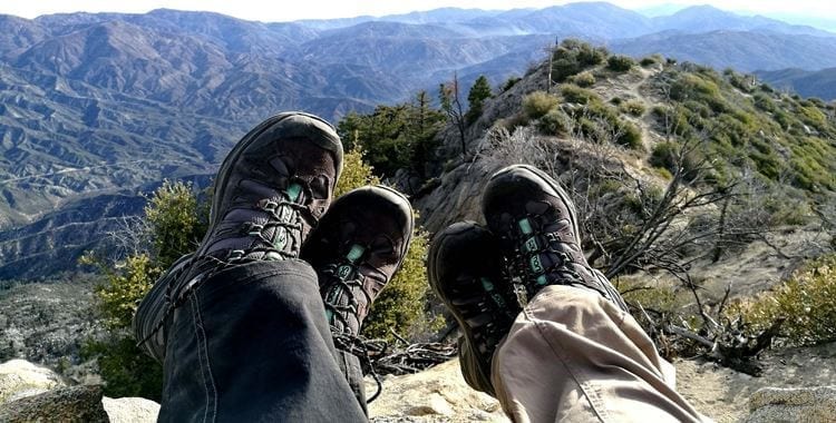 I piedi di due escursionisti con la montagna davanti a loro