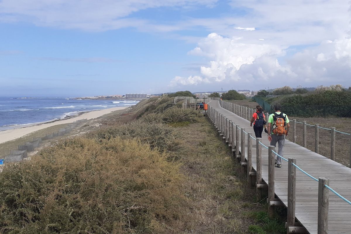 Peregrinos caminando por el Camino Portugués de la Costa llegando a su alojamiento al final de la etapa