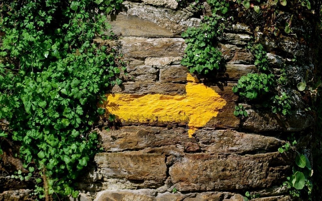 Una freccia gialla dipinta sul muro