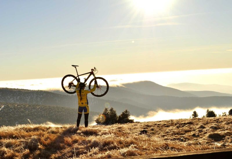 A cyclist with his bike in a mountain