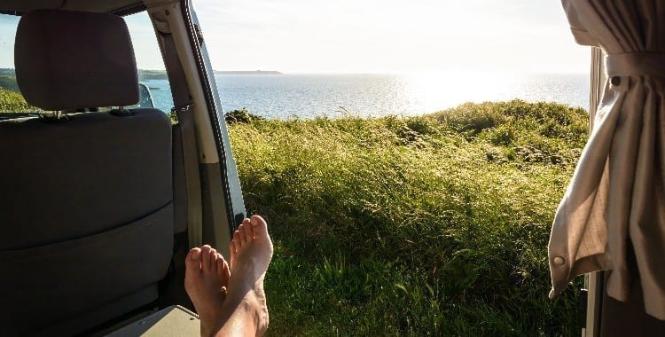 I piedi di una persona in un furgone in riva al mare