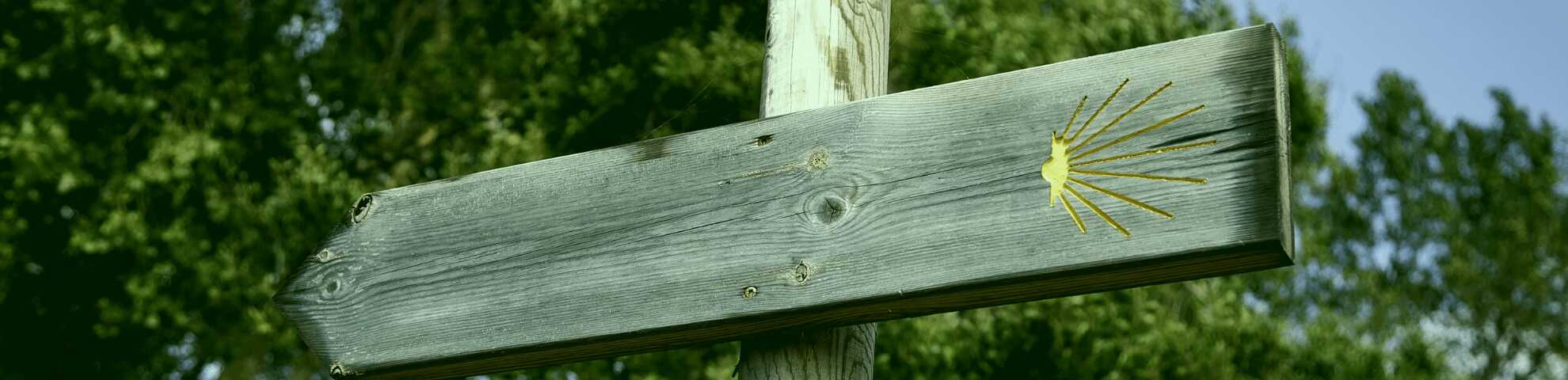 Señal de madera con símbolo del Camino