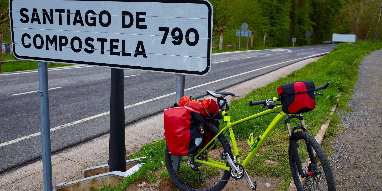 Una bici apoyada en un letrero a Santiago