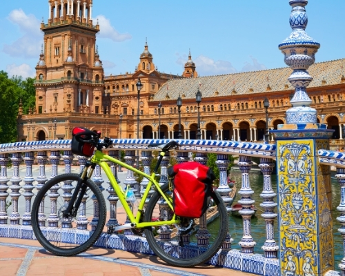Una bici con alforjas apoyada en Plaza España