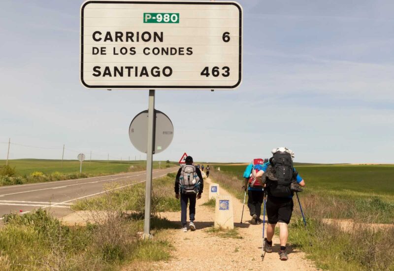 Pilgrims walking along the Camino in Carrión de los Condes