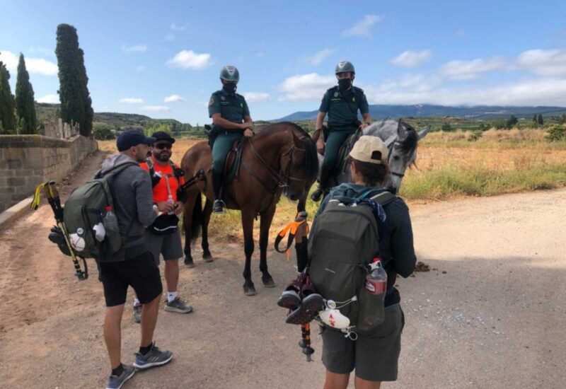 La guardia civil a caballo con unos peregrinos