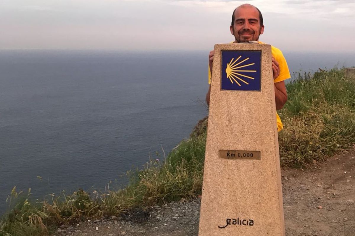 Peregrino feliz tras cumplir una de sus metas de Año Nuevo: llegar al kilómetro 0 en el Camino de Finisterre.