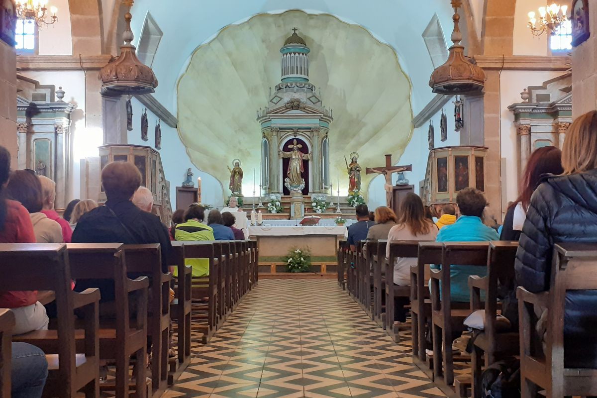 Pilgrims attending a mass during Holy Week at the Santaia de O Pino church, on the French Way